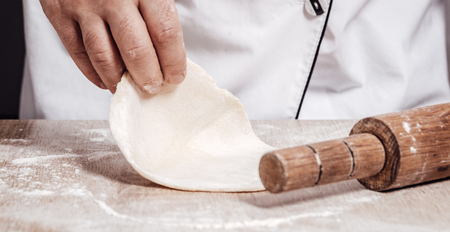 male chef kneads the dough, hands closeupの写真素材