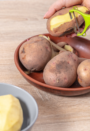 Hand peeling potato closeup photoの写真素材