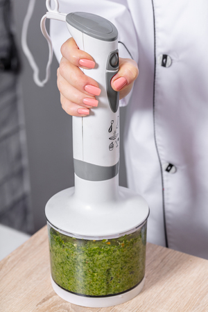 Person blending hot green pepper in a blenderの写真素材