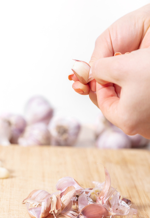 Person peeling garlic cloves closeupの写真素材
