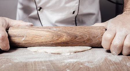 male chef kneads the dough, hands closeupの写真素材
