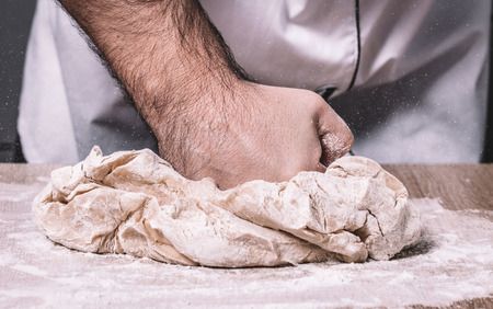 male chef kneads the dough, hands closeupの写真素材