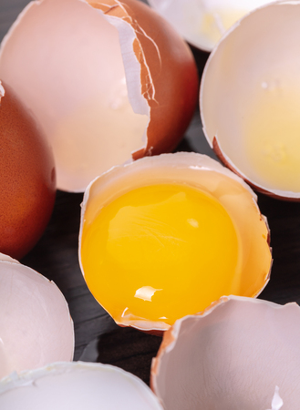 broken hicken eggs close-up on wooden backgroundの写真素材