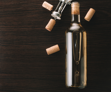 bottle of wine and corkscrew on wooden backgroundの写真素材