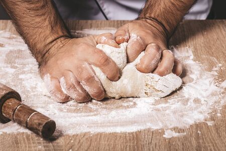 male chef kneads the dough, hands closeupの写真素材