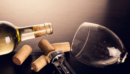 bottle of wine and corkscrew on wooden backgroundの写真素材