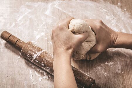 woman chef kneads the dough, hands close-upの写真素材