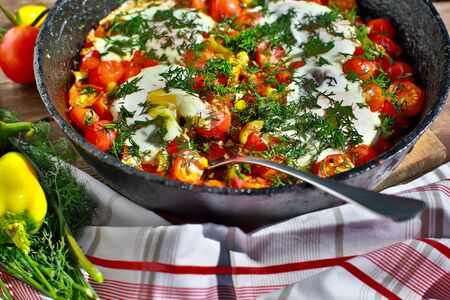 fried eggs with vegetables in a pan, vegetarian breakfastの写真素材