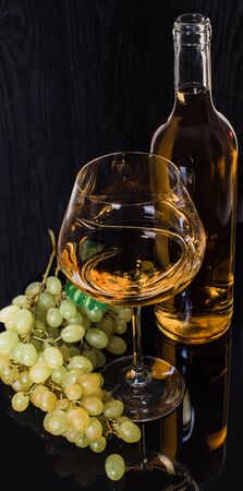 alcohol, white wine with green grapes on a black backgroundの写真素材