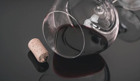 lying glass with red wine and reflectionの写真素材