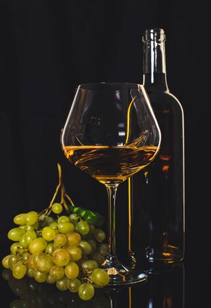 alcohol, white wine with green grapes on a black backgroundの写真素材