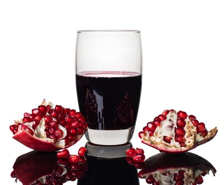 pomegranate juice in a glass and pomegranate with reflectionの写真素材