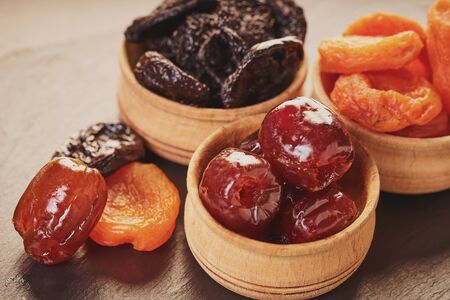 assorted dried fruits in wooden bowls on a table                               の写真素材