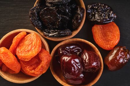 assorted dried fruits in wooden bowls, top view                               の写真素材