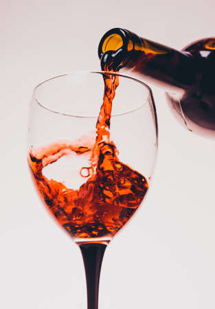 red wine pouring glass on white backgroundの写真素材