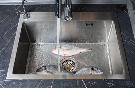 Dorado fish washing under running water