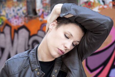 Portrait of a young woman massaging head
