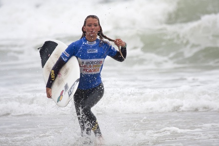 SEIGNOSSE, FRANCE - JUNE 3, 2011: attractive surfer running in the water during her contest  at the Swatch Pro France on June 3, 2011, in Seignosse , France.のeditorial素材