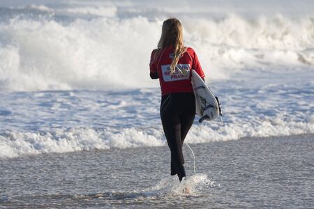 SEIGNOSSE, FRANCE - JUNE 3, 2011: attractive surfer walking in the water with her surfboard  at the Swatch Pro France on June 3, 2011, in Seignosse , France.のeditorial素材