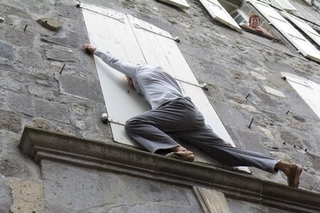 AURILLAC, FRANCE- AUGUST 18: An unidentified man plays in the street as part of the Aurillac International Street Theater Festival, cie " LÃ©zards bleus", on August 18, 2011 in Aurillac, France. のeditorial素材