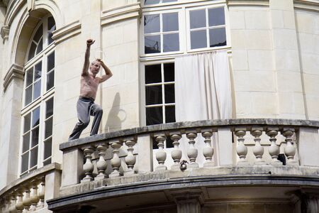 AURILLAC, FRANCE- AUGUST 18: An unidentified man plays in the street as part of the Aurillac International Street Theater Festival, cie " LÃ©zards bleus", on August 18, 2011 in Aurillac, France. のeditorial素材