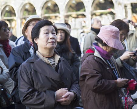 Venice, Italy - November 27, 2011: An elderly tourist is standing on the St mark square. She is looking at the camera while she is listening to her guide. のeditorial素材