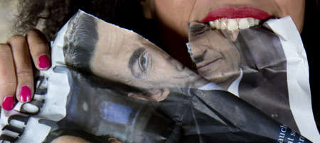 Toulouse, France, April 24, 2011: An anti-Sarkozy protester shows her delighting to see the president Sarkozy defeated. She tears a picture of the french president out of a french newspaper.のeditorial素材