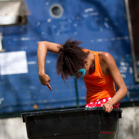 AURILLAC, FRANCE - AUGUST 23: A dancer is standing in a trash can as part of the Aurillac International Street Theater Festival,show by the Company Empreintes, on august 23, 2012, in Aurillac,France. のeditorial素材