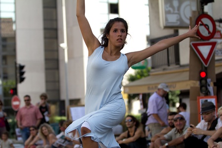 AURILLAC, FRANCE - AUGUST 22: a young woman dances in the street as part of the Aurillac International Street Theater Festival,show by the Company Rebus ,on august 22, 2012, in Aurillac,France.のeditorial素材