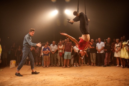 AURILLAC, FRANCE - AUGUST 22: a trapeze artist moves in the middle of a big top as part of the Aurillac International Street Theater Festival, Company Off ,on august 22, 2012, in Aurillac,France.のeditorial素材