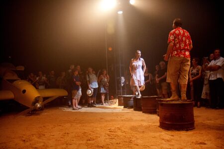 AURILLAC, FRANCE - AUGUST 22: a couple is walking on petrol cans in the middle of a big top, Aurillac International Street Theater Festival, Company Off ,on august 22, 2012,in Aurillac,France.のeditorial素材