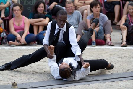 AURILLAC, FRANCE - AUGUST 24: fight between a man and a woman, Aurillac International Street Theater Festival,  Brigade d'intervention théâtrale Haïtienne, on august 24, 2012, in Aurillac,France.のeditorial素材