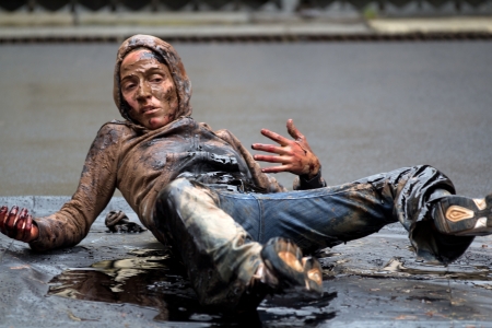 AURILLAC, FRANCE - AUGUST 22: a very dirty woman moves on the ground as part of the Aurillac International Street Theater Festival, show named Vachement, on august 22, 2012, in Aurillac,France.のeditorial素材
