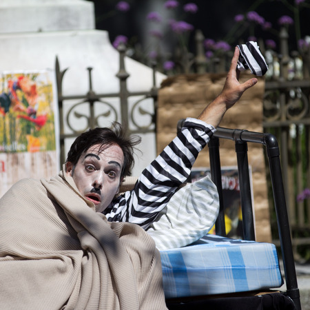 AURILLAC, FRANCE - AUGUST 21  a clown is showing a striped beret as part of the Aurillac International Street Theater Festival, Company Les hommes papillon,on august 21, 2013, in Aurillac,France のeditorial素材