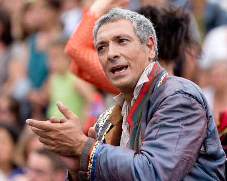 AURILLAC, FRANCE - AUGUST 23  mature actor clapping in the middle of the crowd as part of the Aurillac International Street Theater Festival, Company Oposito,on august 23, 2013, in Aurillac,France のeditorial素材