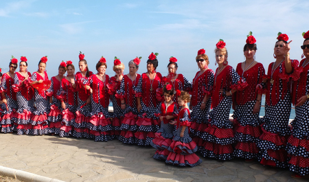 NERJA, SPAIN -  OCTOBER 6   Some women and two little girls from an Andalusian folk group are wearing traditional red costumes and are waiting for a photo, on October 6, 2013, in Nerja, Spain   のeditorial素材