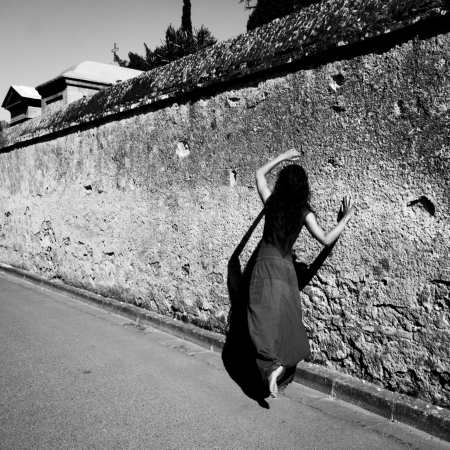 Brunette dancer moves barefoot along an old wall, in L Isle Jourdain, Gers, France の写真素材