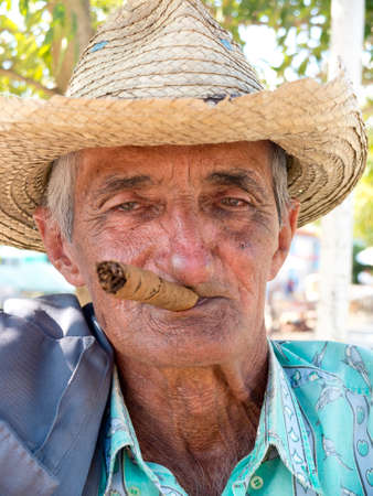 VINALES, CUBA - DECEMBER 16: an old man wearing a straw hat is smoking a cuban cigar outdoors, we december 16, 2014, in Vinales, Cubaのeditorial素材