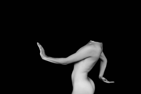 Decapitated body like a greek statue. This is a black and white image. The background is black.の写真素材
