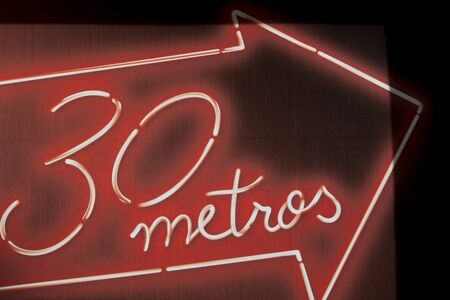 CARTAGENA, SPAIN-JANUARY 29, 2019: Illuminated red and white sign mounted on a wall. It's a notice for a direction. The heart of the world is a distance "30 meters" written in an arrow.のeditorial素材