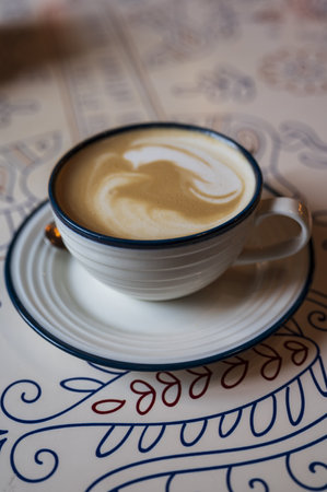 Cup of cappuccino with latte art on table