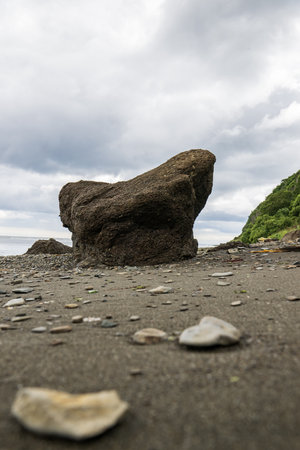 Rock on the beach with cloudy sky background, nature background and wallpaperの写真素材