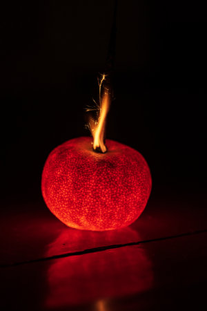 Glowing tangerine in the dark, close-up.の写真素材