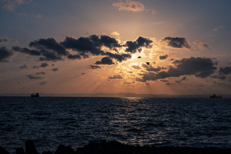 Sunset over the sea with dramatic clouds and rays of light.