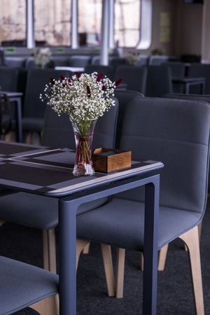 Interior of a restaurant with chairs, table and bouquet of flowersの写真素材