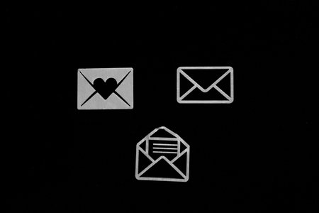 Postal envelope with heart and love symbol isolated on black background.