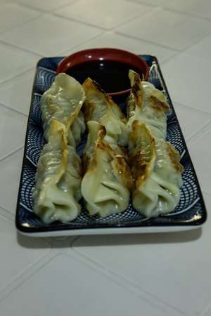 Japanese gyoza dumplings with soy sauce on a plateの写真素材