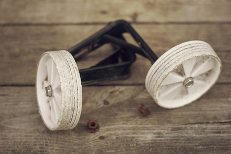 Old training wheels taken off the bike, sitting on a porch.  Vintage, retro themeの写真素材