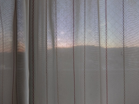 Sunset through lace curtainsの写真素材