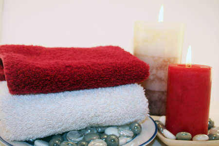 A relaxing setting of candles and towels ready for a relaxing bath or soothing massage.の写真素材